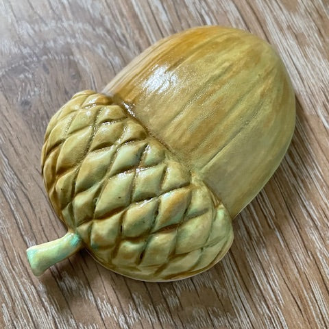 Decorative acorn-shaped object on a wooden surface