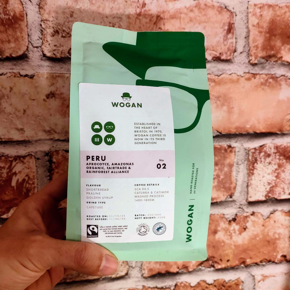 Wogan coffee package held against a brick wall
