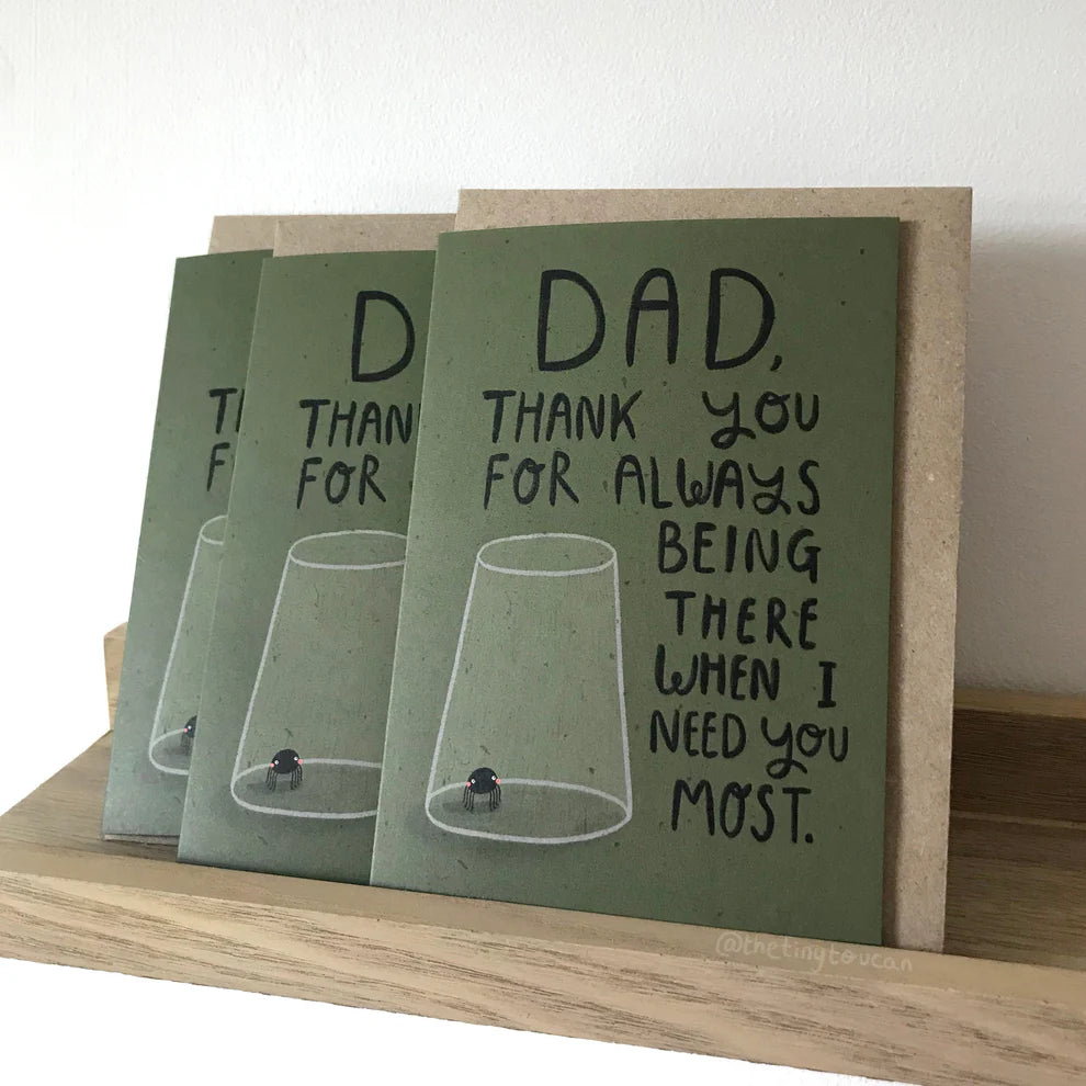 Three green greeting cards with a message to a father on a wooden surface.