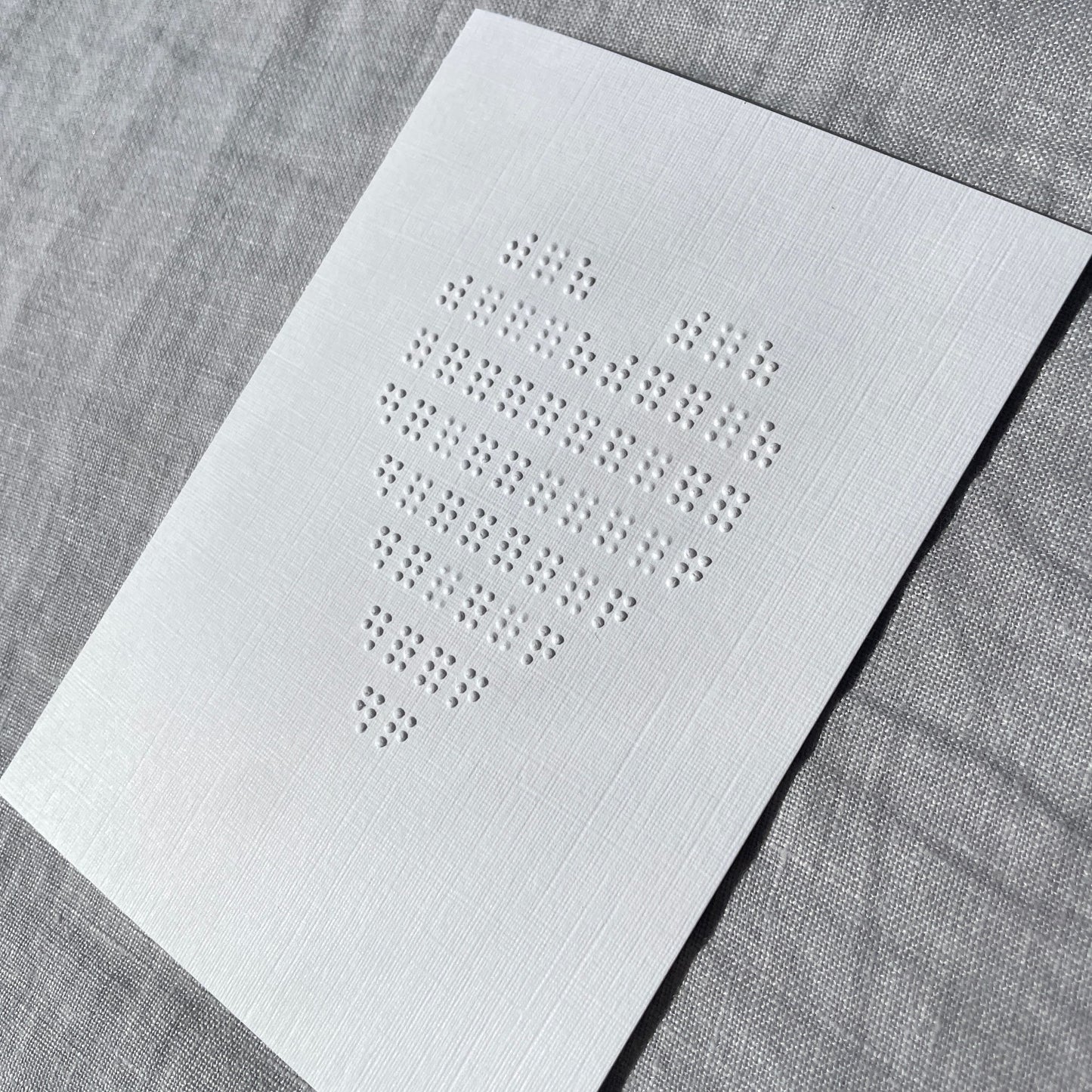 White card with embossed heart on a white background