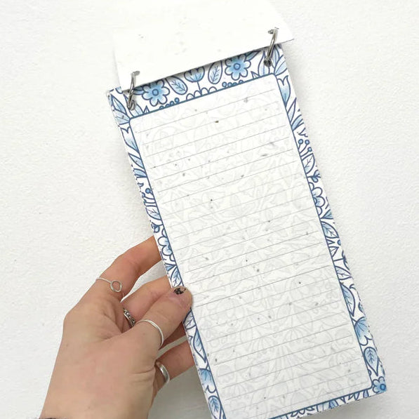 Hand holding a small white board with blue border against a white background