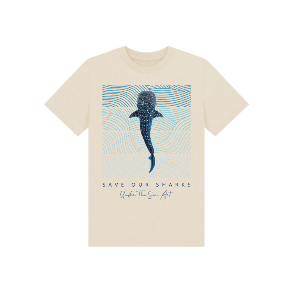 A cream-colored short-sleeve t-shirt with a graphic print of a blue whale shark on a light blue patterned background, with the text 'SAVE OUR SHARKS' and 'Under The Sea Art' printed below.