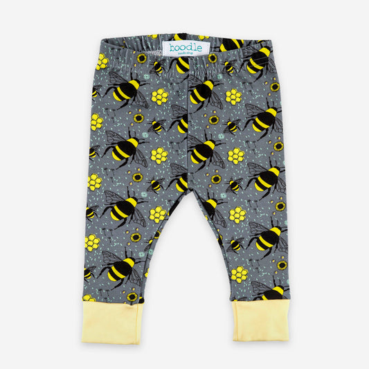 Gray patterned baby leggings with a yellow and black bumblebee print, featuring light yellow cuffed hems and a visible 'boodie' brand label at the waistband.