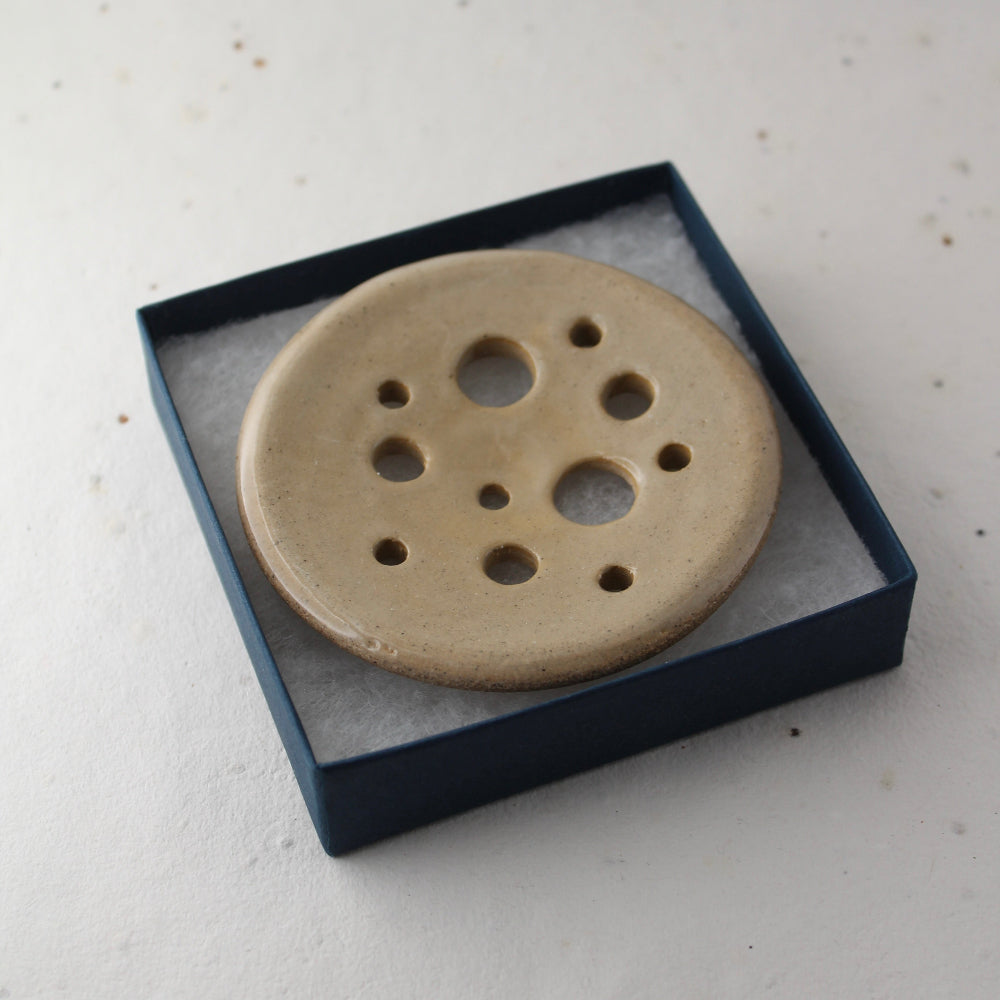 Ceramic disc with holes in a blue box on a white background