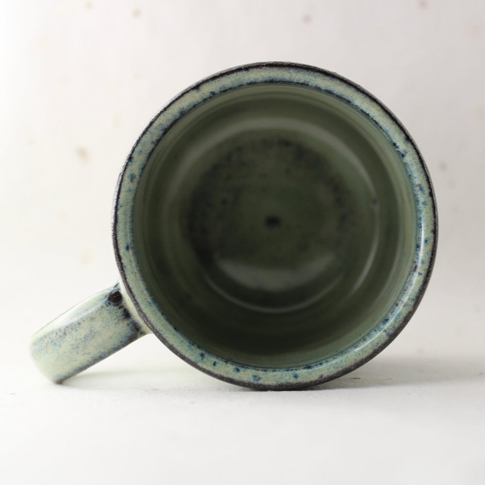 Ceramic mug with speckled design on a white background